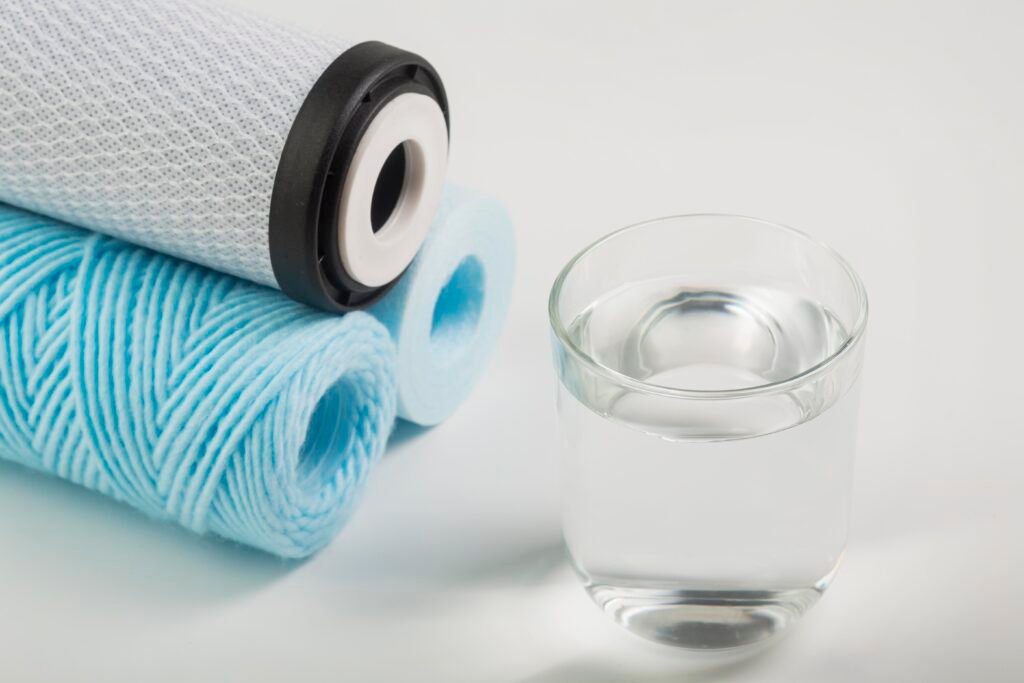 Clean water filtration cartridges with glass of purified drinking water
