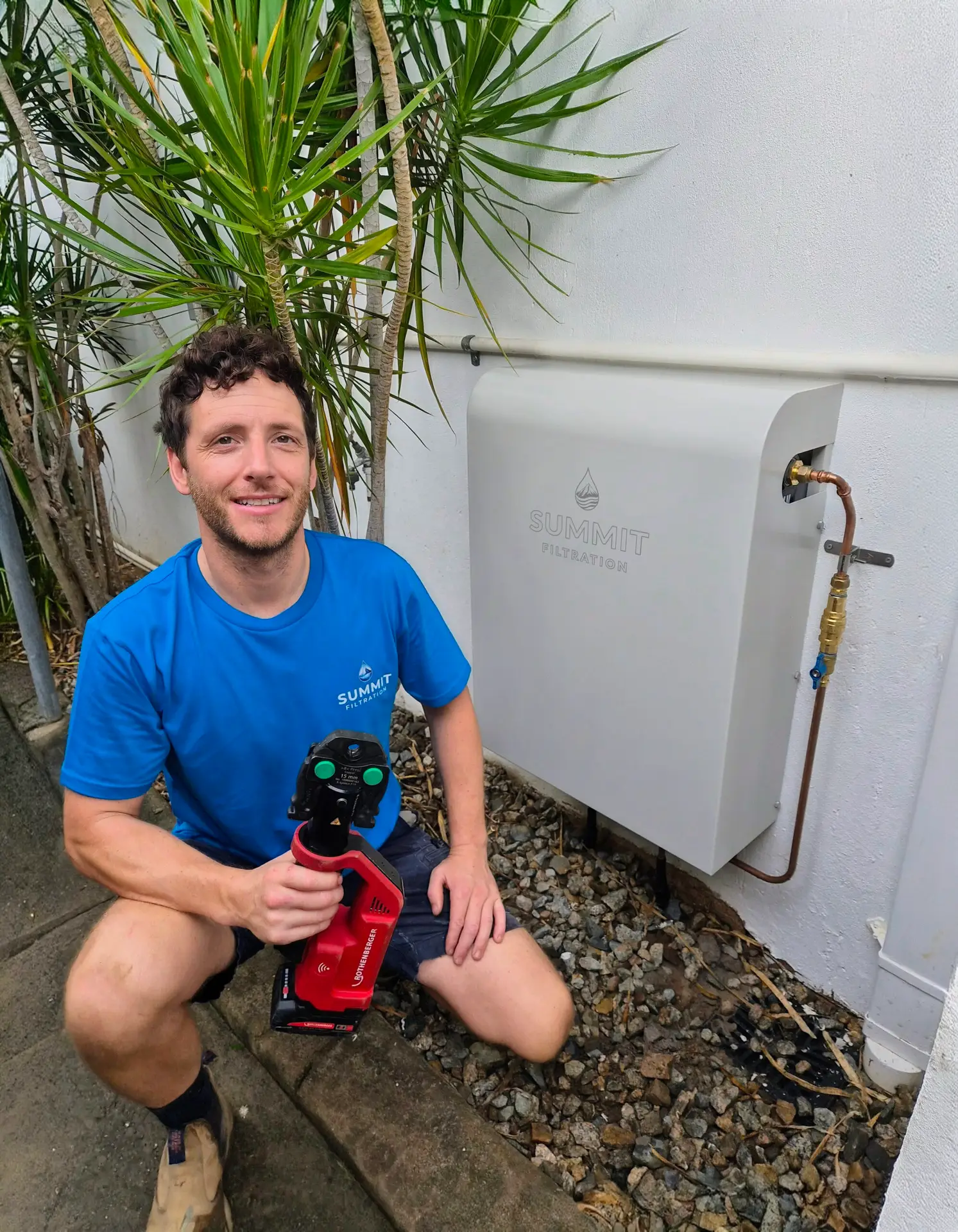 Summit filtration licensed plumber installing white whole house water filter.